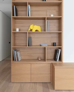 A modern wooden living room with a yellow elephant figurine, books, and cabinets.