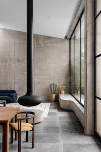 Modern, minimalist residential hallway featuring concrete walls and floor.