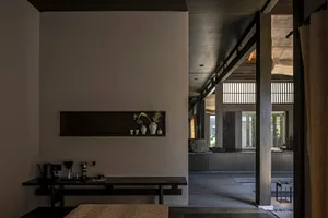 Modern residential interior with a minimalist design featuring concrete materials and natural light.