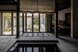 A minimalist modern living room interior with concrete flooring and steel columns.