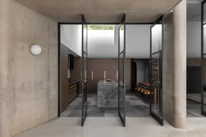 Modern kitchen featuring minimalist design with concrete walls, marble countertops, and a central island.