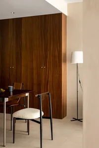 A minimalist dining room with wooden cabinets, a table, and two chairs.