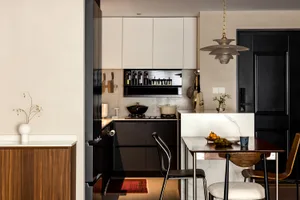 A modern kitchen with marble countertops, black and white color scheme, and minimalist design.