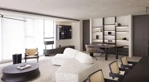 Modern living room and office space with white sofa, dark wood furniture, and open shelving.