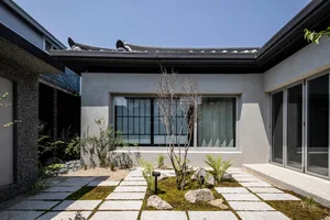 Minimalist residential courtyard featuring modern concrete and glass materials.