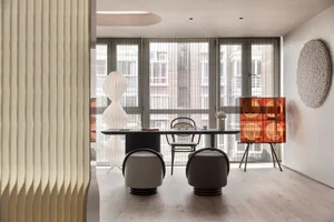 Modern dining room featuring a wooden table and chairs, with a contemporary chandelier and minimalist decor.