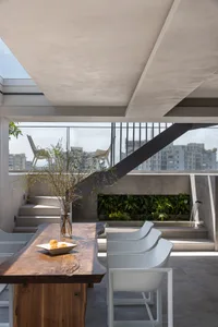 Outdoor dining area featuring industrial design elements with concrete materials and a modern aesthetic.