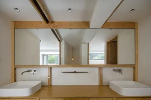 A minimalist bathroom with a wooden countertop and two sinks.