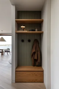 A modern entryway featuring a wooden shelving unit with metal accents.