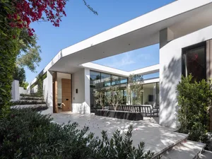 A modern house featuring a mix of concrete, glass, and steel materials.