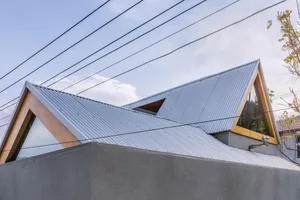 一座擁有金屬屋頂與幾何建築設計的現代閣樓建築。