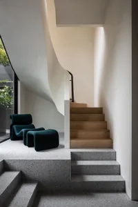 A modern concrete staircase with wooden steps in a minimalist interior design space.