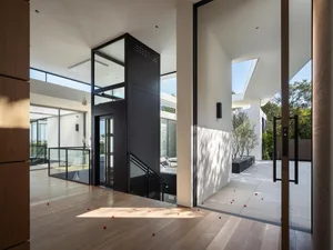 Contemporary home interior featuring glass, wood, and metal elements.