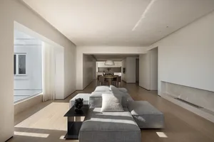 A modern living room with neutral-toned furniture and minimalist design.