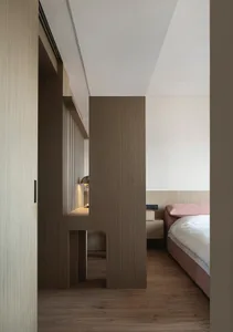 A minimalist bedroom featuring wooden furniture and floors.