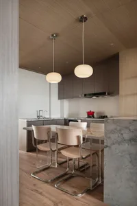 Modern minimalist kitchen with marble countertops and pendant lighting