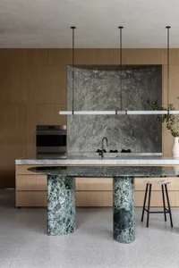 Modern residential kitchen featuring a marble countertop and column base.