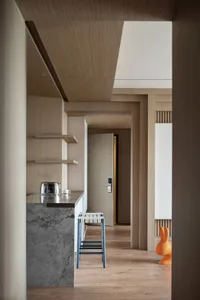 A modern residential kitchen with wooden finishes and a bar counter.