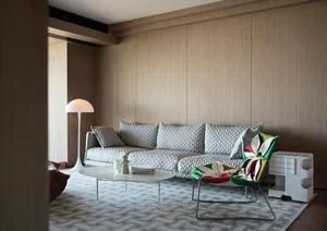 Modern living room with wooden paneled walls, grey sofa, and white coffee table.
