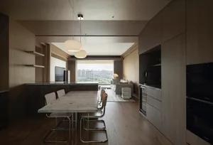 Modern apartment featuring a stone-top dining table and minimalist furniture, with a view of the cityscape.