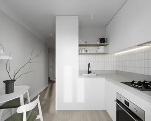A minimalist kitchen with white cabinets and a modern design.