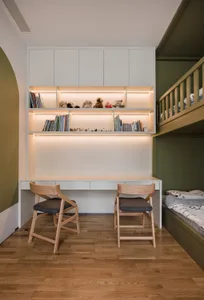 A modern bedroom featuring a wooden desk with integrated storage and shelves.