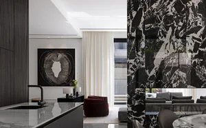 Modern interior design with black marble flooring and walls, contemporary furniture, and abstract art.