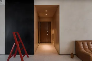Modern home entryway featuring concrete flooring and wooden walls.