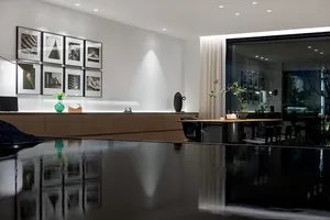 現代簡約風格的廚房與餐廳，搭配流線黑桌椅、白牆與自然採光。