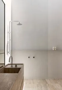 A minimalist bathroom with a concrete sink and floor, contemporary design elements.