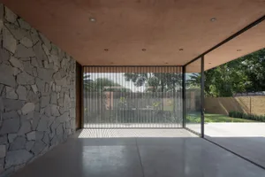 A modern interior featuring glass walls and a stone exterior.
