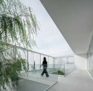 A modern interior design featuring glass, concrete, and steel materials.