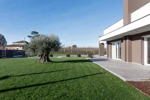 A modern residential exterior featuring concrete and glass materials.