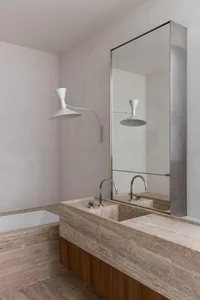 Modern bathroom with a stone countertop and a white bathtub.