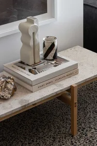 A coffee table made of marble featuring decorative ceramic objects.