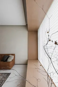 A modern interior living room featuring a wooden window sill and a comfortable seating area.
