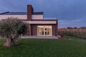 A modern residential exterior with minimalist design, featuring large windows and a sleek, contemporary style.