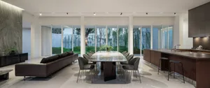 Modern living, dining, and kitchen space featuring marble walls, leather couch, and wooden furniture.