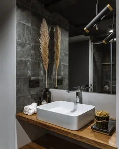 Modern bathroom featuring a concrete sink, wooden countertop, and minimalist design.