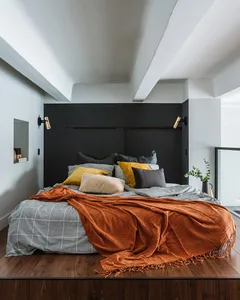 A cozy modern bedroom with a bed and wooden floor at night.