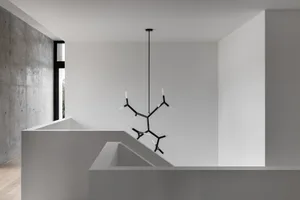 Modern interior with minimalist design, featuring concrete and white walls, and a unique lighting fixture.