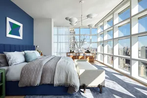 Modern minimalist bedroom with gray and glass elements.