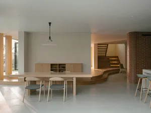 現代簡約客廳餐廳空間，搭配木質家具與樓梯。