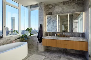 Modern bathroom featuring marble and wooden finishes.