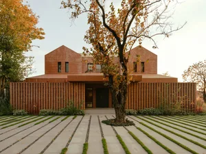 A modern brick house with a tree in the foreground.