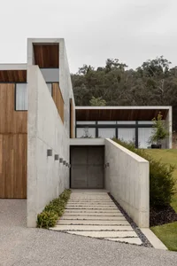 A modern house exterior featuring concrete and wooden walls.