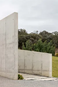 A modern exterior wall made of smooth, light-colored cement with a minimalist design.