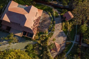 Aerial view of a modern house with brick exterior featuring a circular driveway and garden.