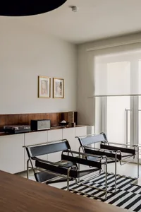 A minimalist living room featuring modern black leather and metal furniture.