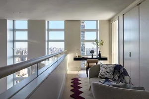 A modern minimalist residential interior with large windows and a view of the city.
